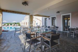 restauracja ze stołem i krzesłami oraz basenem w obiekcie Perivoli Country Hotel & Retreat w Nauplionie