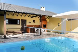 a villa with a swimming pool and a house at Casa Guaratuba-Barra do Saí - "Recanto de Milady" - 80 m da Praia in Guaratuba