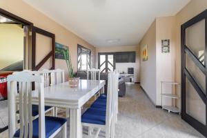 a dining room with a white table and chairs at Casa Guaratuba-Barra do Saí - "Recanto de Milady" - 80 m da Praia in Guaratuba