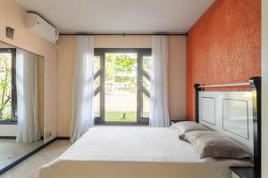 a bedroom with a bed and a large window at Casa Guaratuba-Barra do Saí - "Recanto de Milady" - 80 m da Praia in Guaratuba +22 photos