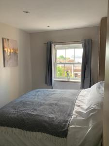 a bedroom with a bed and a window at The Beachfront Lookout a Stunning Apartment with Perfect Sea View in Worthing