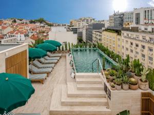 een zwembad op het dak van een gebouw met parasols bij Browns Avenue Hotel in Lissabon