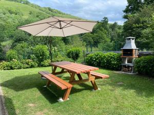 a picnic table with an umbrella and a grill at Casa Fresneda in Fresneda