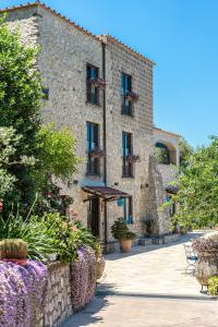 un gran edificio de piedra con plantas delante de él en Villa Denise, en Vico Equense