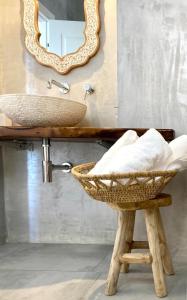 a bathroom with a sink and a mirror and a stool at Dimora delle Tonnare in Favignana