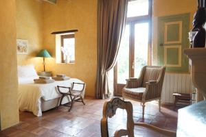Lapalud的住宿－Maison en Provence，卧室配有一张床和一张桌子及椅子