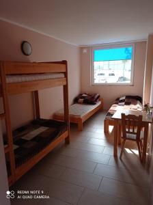 a bedroom with two bunk beds and a table at LKS Charzykowy 4 in Charzykowy