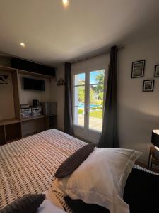 1 dormitorio con 1 cama grande y ventana en Chambre avec salle de bain privée de la Canopée de Mios, en Mios