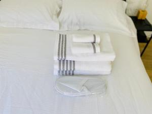 a pile of towels sitting on top of a bed at Studio équipé-climatisé avec balcon au Mourillon à 20m de la plage in Toulon