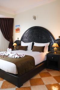 a bedroom with a large bed with a large headboard at Hôtel Riad Salam Agadir in Agadir