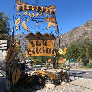 un cartel con una casa al lado de una carretera en Cabañas La Calchona en Melocotón