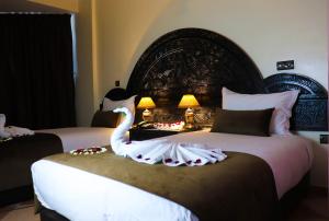 a bedroom with two beds with a swan on the bed at Hôtel Riad Salam Agadir in Agadir