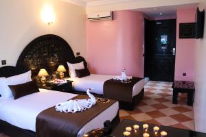 ein Hotelzimmer mit 2 Betten mit Schwänen darauf in der Unterkunft Hôtel Riad Salam Agadir in Agadir