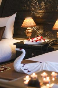 a bedroom with a bed with a swan on a table at Hôtel Riad Salam Agadir in Agadir