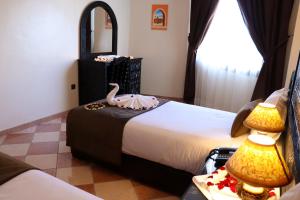 a bedroom with a bed with a swan on it at Hôtel Riad Salam Agadir in Agadir