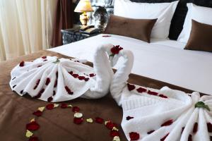 two swans dressed in towels sitting on a bed at Hôtel Riad Salam Agadir in Agadir