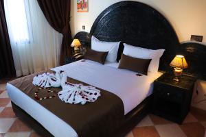 Un dormitorio con una cama grande con un cabecero grande. en Hôtel Riad Salam Agadir, en Agadir