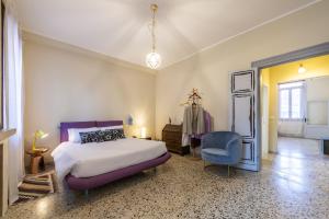 a bedroom with a bed and a blue chair at Amor Mio B&B in Venice
