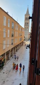 eine Gruppe von Menschen, die eine Stadtstraße entlang laufen in der Unterkunft Cardo Apartments in Zadar