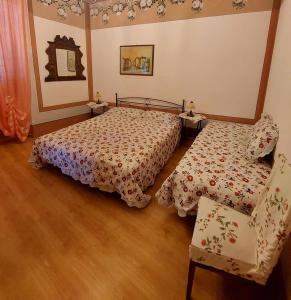 リオ・マリーナにあるAppartamento Gialloのベッドルーム1室(ベッド2台、椅子付)
