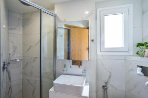 biała łazienka z umywalką i prysznicem w obiekcie Elia Residences w Chanii +37 zdjęć