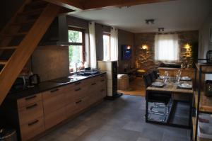 a kitchen with a sink and a table in it at Mon petit cocon in Jalhay