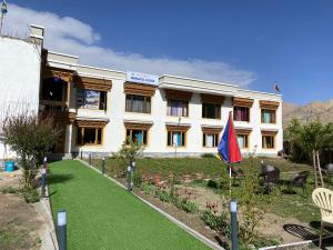 a building with a lawn in front of it at Mangyul guest house in Leh