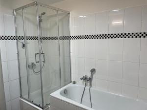 La salle de bains blanche est pourvue d'une douche et d'une baignoire. dans l'établissement Große moderne Ferienwohnung, ruhige Innenstadtlage, à Cassel