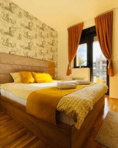 een slaapkamer met een groot bed met gele kussens bij Lux Apartmani Vojinović in Zlatibor