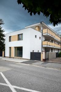 a white building on the side of a street at TREND BA HOME Apartman in Balatonalmádi