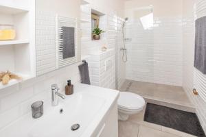 a white bathroom with a toilet and a sink at TREND BA HOME Apartman in Balatonalmádi +9 photos