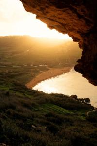 a view of a beach from inside a cave at The Segond Hotel in Xagħra