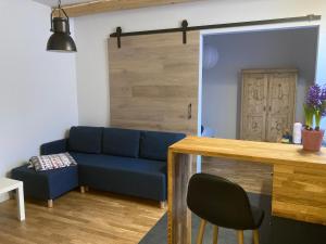 a living room with a blue couch and a table at Chata pod Rogową Apartamenty in Javorina