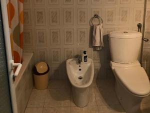 a bathroom with a toilet and a bidet and a tub at Lovely Apartment in front of the Lake in Pogradec