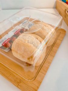 a sandwich in a plastic container on a cutting board at Pension As Burgas Ii in Caldas de Reis