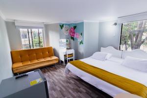 a bedroom with a large bed and a couch at ApartaSuites & Hotel Bogota Suamox in Bogotá