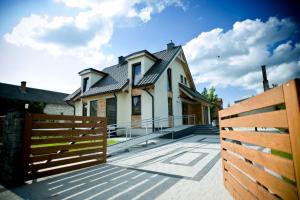 a house with a wooden fence in front of it at Villa Comfort in Zamość