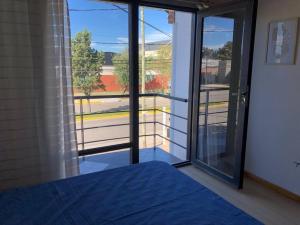 Pokój z dużymi przeszklonymi drzwiami z widokiem w obiekcie Amplia casa dos pisos, estacionamiento, patio. w mieście Puerto Madryn