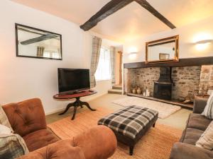 a living room with a tv and a fireplace at Holloway House in Wotton-under-Edge