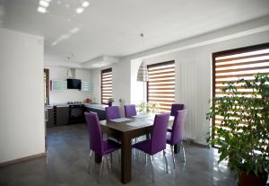 扎莫希奇的住宿－舒適別墅，一间用餐室,配有紫色椅子和一张桌子