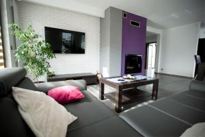 uma sala de estar com um sofá e uma mesa em Villa Comfort em Zamość