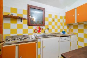 a small kitchen with a sink and a mirror at Villetta Cala D'Ambra in San Teodoro