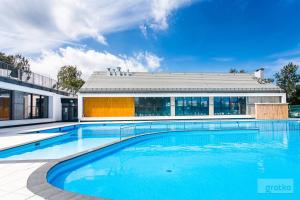 a large swimming pool in front of a building at ApartamentyPrzyMorzu Apartament z basenem i bawialnią in Kołobrzeg