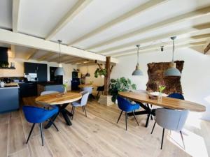 ein Esszimmer mit einem Holztisch und blauen Stühlen in der Unterkunft Bed and Breakfast Lauwersstate in Paesens