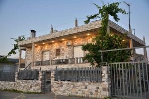 a stone house with a fence in front of it at Stone Villa in Korinthos