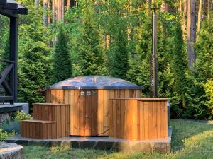 an outdoor hot tub in a garden with trees at Domek w lesie nad zalewem in Chańcza