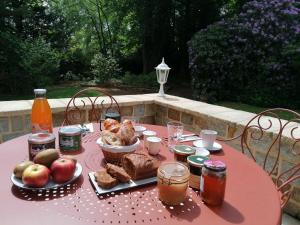 - une table rose avec de la nourriture et des boissons dans l'établissement Villa Matignon, à Bagnoles-de-l'Orne