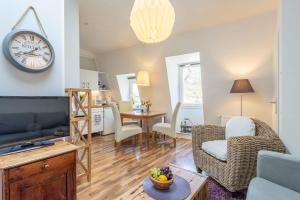 a living room with a couch and a clock on the wall at Captains Haven in Eckernförde