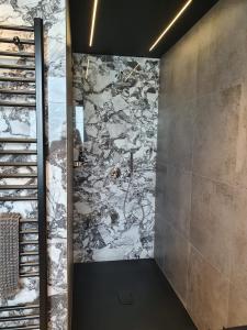a walk in shower with a stone wall at Visioni Lake View Boutique Rooms & Breakfast - Adults Friendly in Riva del Garda