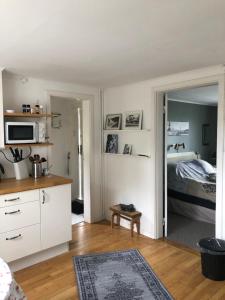 a room with a bed and a kitchen with a mirror at Villagatan in Norrtälje